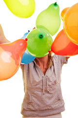 Junge Frau wirft bunte Ballons