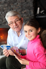 portrait d'une fillette jouant aux cartes avec son grand-père