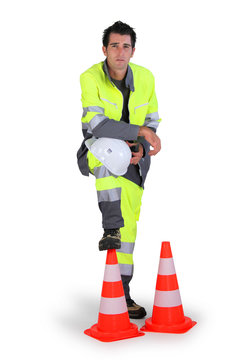 ouvrier debout près de cônes de sécurité