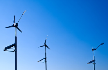 The wind turbines with solar panels against a blue sky