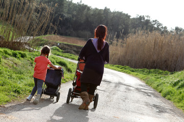 Mother and her daughter push their prams together