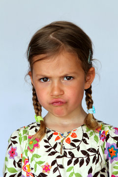 Studio portrait of young girl showing disgust and disapproval