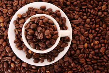 Small white cup of coffee with coffee grain on grain background
