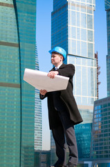 Engineer with blue hard hat holding drawing