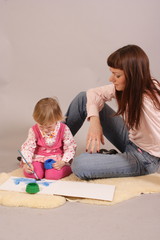 young mother with her daughter drawing