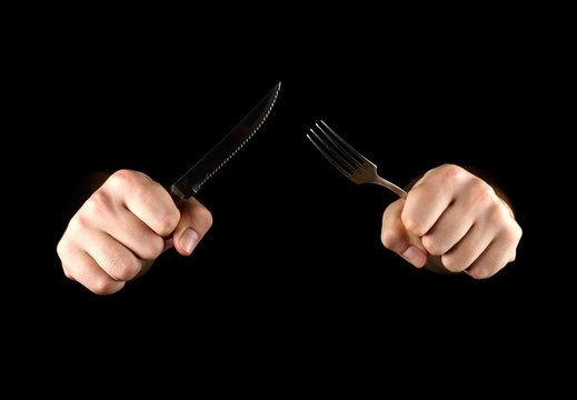 Hand With Knife And Fork On Black Background