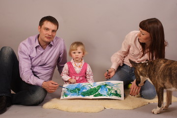 young family with their daughter drawing