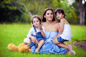 Mother and two daughters playing in grass