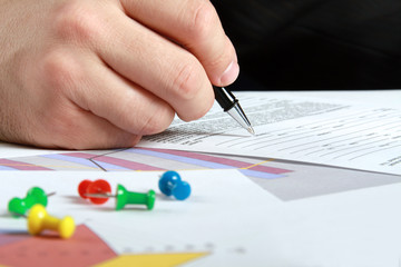Male hand is writing in the document