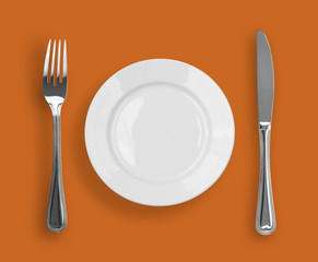 Knife, plate and fork on color background