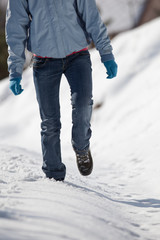 Fototapeta na wymiar pretty young woman walking in deep snow on a sunny winter day