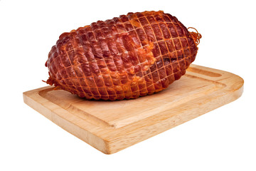 Big tasty smoked ham on desk isolated over white background.