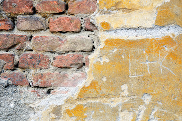 Fragment of tumbledown plastered brick wall
