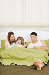 happy family relaxing in bed