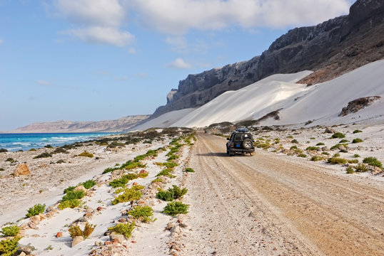 Ocean, mountain, white dune and car