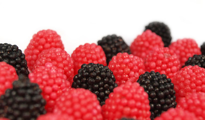 Sweet raspberries and blackberries on white background