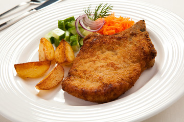 Grilled meat with chips and vegetables