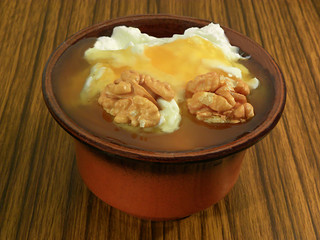 Yogurt with honey and walnuts in a clay cup