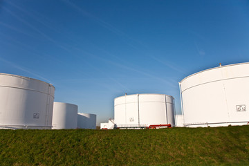 white tanks in tank farm with blue sky