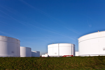 white tanks in tank farm with blue sky