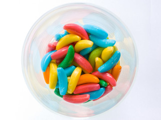Banana shaped candy in a pot on white