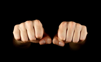 Two fists isolated on black background.
