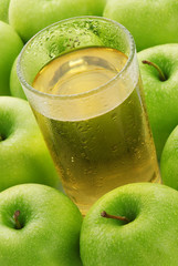 Glass with juice on a background of apples
