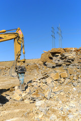 Strommasten hinter Steinbruch