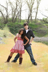 Teen boy and girl coupe outdoors striking a pose