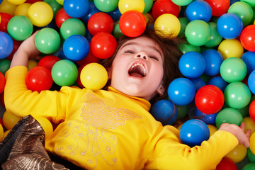 Fototapeta na wymiar Child in group of colourful ball.