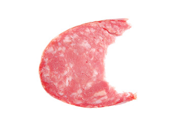 The bitten off piece of sausage on the white