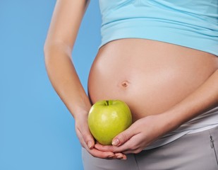Pregnant woman with green apple