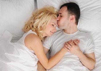 Obraz na płótnie Canvas Young couple sleeping in a bed