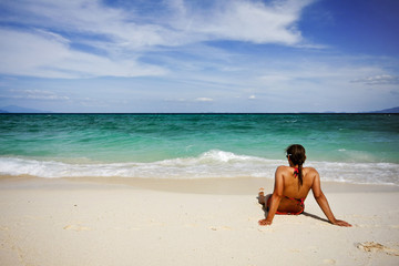 Girl sitting on paradise beach