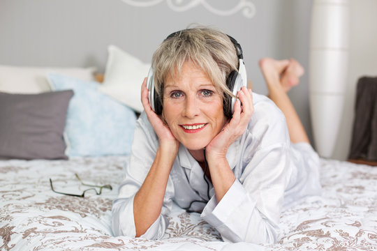 moderne seniorin hört musik mit kopfhörer