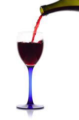 Red wine flowing from a green bottle to a glass.Isolated on whit