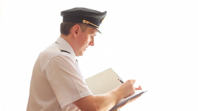 Airline pilot filling in and checking papers