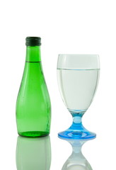 Bottle and glass of mineral water reflected on white background
