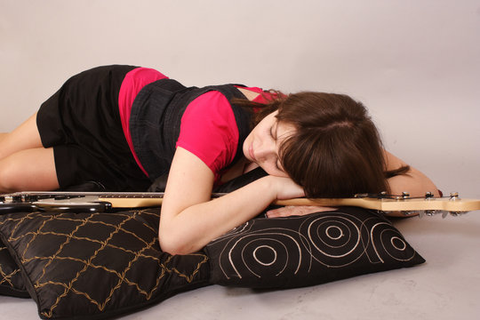 young beautiful woman with a bass guitar - asleep