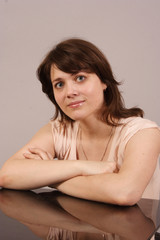 a young woman sitting at a glass table