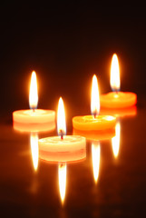 Burning candles isolated on black