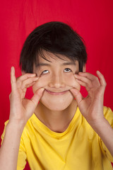 portrait of 13 year old Asian boy making funny face
