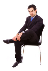 Young businessman sitting on chair, against white background