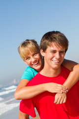 Fototapeta na wymiar brother and sister piggyback ride on beach