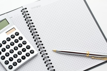 Close-up of calculator, pen and note on table