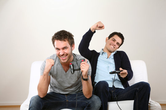 zwei maenner lachen und spielen Computerspiel
