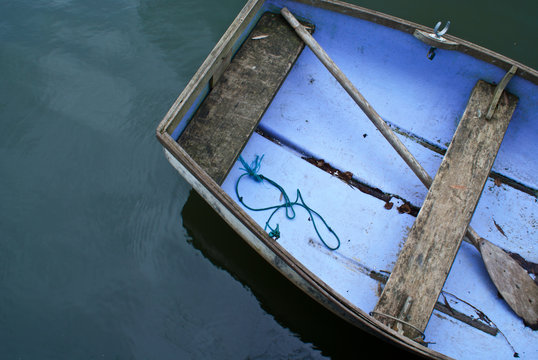 A portion of an aged rowboat on the water taken from above