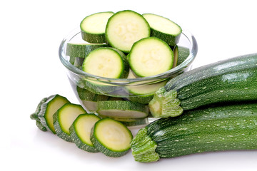 Rondelles de courgettes dans un bol transparent sur fond blanc