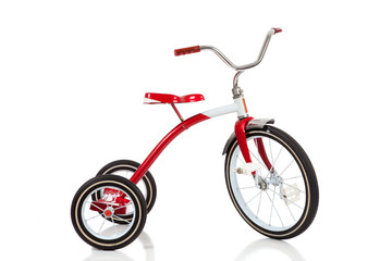 Child's red tricycle on white