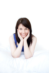 Portrait of a smiling woman sitting on her bed